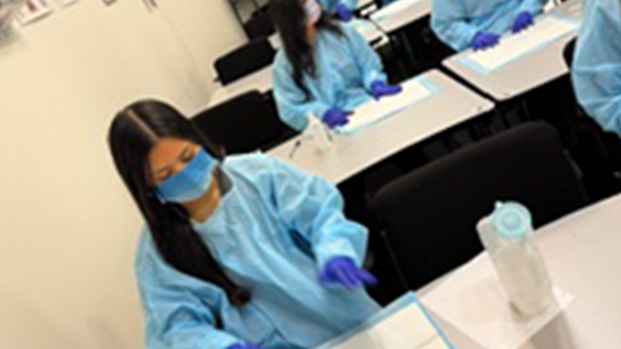 Phlebotomy training students practicing lab procedures in a classroom setting